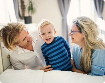 adults looking at a boy smiling